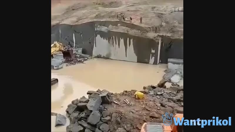 An excavator is knocking down a concrete wall. Video joke